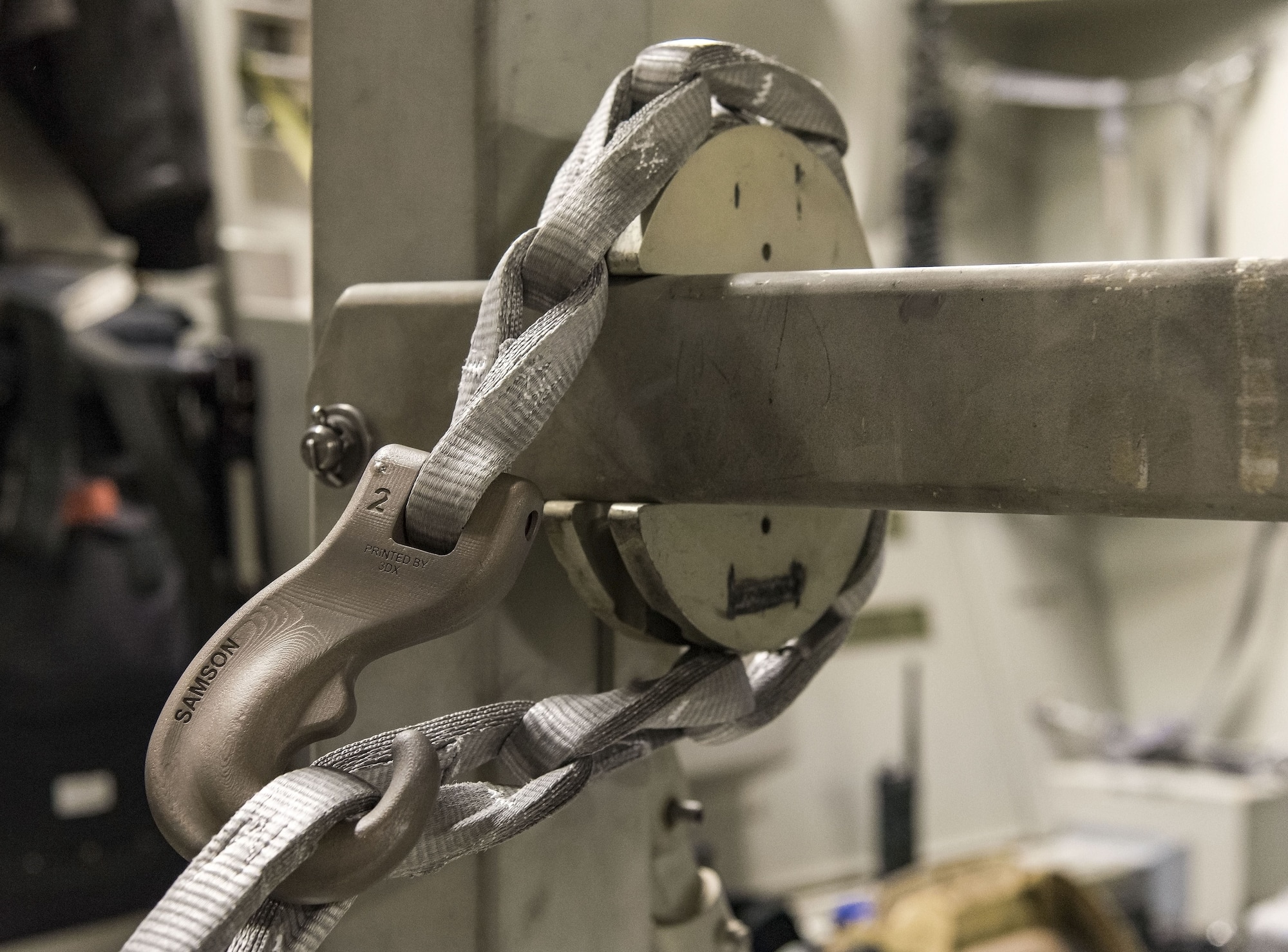 A synthetic tie-down chain rests in the slotted interface designed for steel chains used on a buffer stop assembly, Jan. 30, 2018 at Dover Air Force Base, Del. The buffer stop assembly is a device used during specific C-17 Globemaster III airdrop missions to keep pallets from shifting forward in the cargo compartment. (U.S. Air Force photo by Roland Balik)