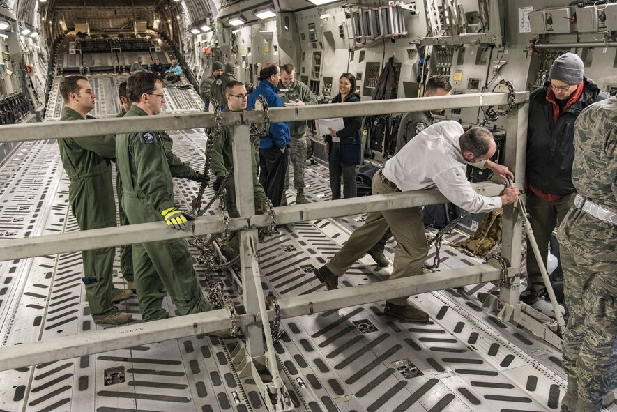 Justin Smoak, Samson Rope application engineering manager, Ferndale, Wash., places a synthetic chain into the slotted interface on the C-17 Globemaster III buffer stop assembly, Jan. 30, 2018 at Dover Air Force Base, Del. The buffer stop assembly is a device used during specific C-17 Globemaster III airdrop missions to keep pallets from shifting forward in the cargo compartment. (U.S. Air Force photo by Roland Balik)