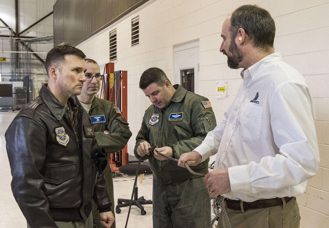 Senior Master Sgt. Jeff Witherly, Headquarters, Air Mobility Command C-17 evaluator loadmaster, Scott AFB, Ill.; Master Sgts. David Feaster and Elliott McClanahan, both 3rd Airlift Squadron loadmasters; listen to Justin Smoak, Samson Rope application engineering manager, Ferndale, Wash., talk about the construction of the winch cable Jan. 30, 2018 at Dover Air Force Base, Del. The 280-foot long steel cable currently used on C-17 Globemaster III aircraft winches weigh 80 pounds versus the proposed synthetic winch cable only weighing 14 pounds. (U.S. Air Force photo by Roland Balik)