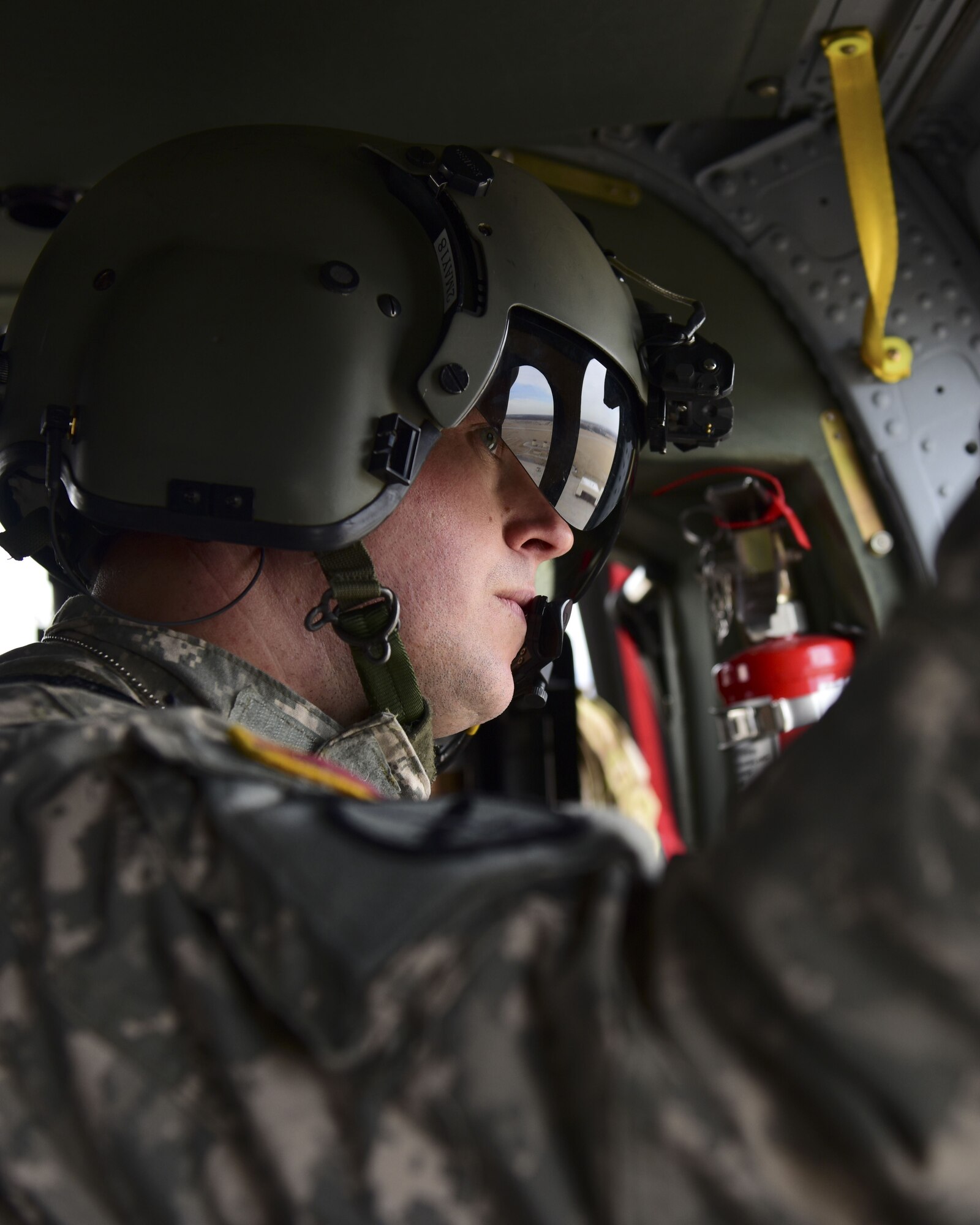 A U.S. Army crew chief with the 1-135th Assault Helicopter Battalion looks out a window of a UH-60 Black Hawk during a joint training mission at Whiteman Air Force Base, Mo., Jan. 31, 2018. In addition to establishing a partnership, the purpose of the training was to familiarize Joint Terminal Attack Controllers from the 7th Air Support Operations Squadron, located in Fort Bliss, Texas, with the assets available at Whiteman AFB that are used in a multi-domain fight. (U.S. Air Force photo by Staff Sgt. Danielle Quilla)