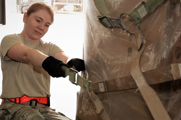 Staff Sgt. Jennifer Shippy, 21st Logistics Readiness Squadron, secures a cargo net around boxes of donated winter weather gear inside the 39th Aerial Port Squadron’s loading bay at Peterson Air Force Base, Colorado, Jan. 29, 2018. The winter clothes, donated by Cyrus International, Inc., are being transported via a C-17 Globemaster aircraft from March AFB, California, to mountainous villages in Afghanistan. (U.S. Air Force photo by Staff Sgt. Frank Casciotta)