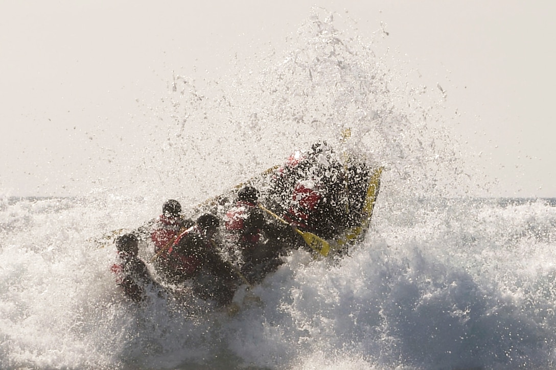 Sailors in an open boat ride over explosive surf.
