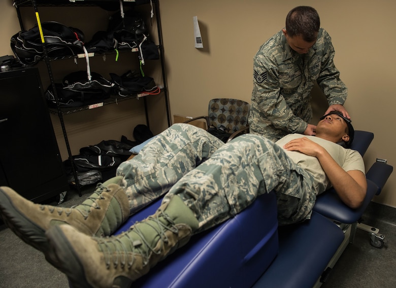 Staff Sgt. Geoffrey Rigby, 56th Medical Operations Squadron physical therapy technician, demonstrates physical therapy techniques on another physical therapy tech, Senior Airman Omar Irvin, at Luke Air Force Base, Feb. 6, 2018. Rigby used his physical therapy knowledge to help save a life after a car crash Jan. 16 in Glendale, Ariz. (U.S. Air Force photo/Airman 1st Class Alexander Cook)