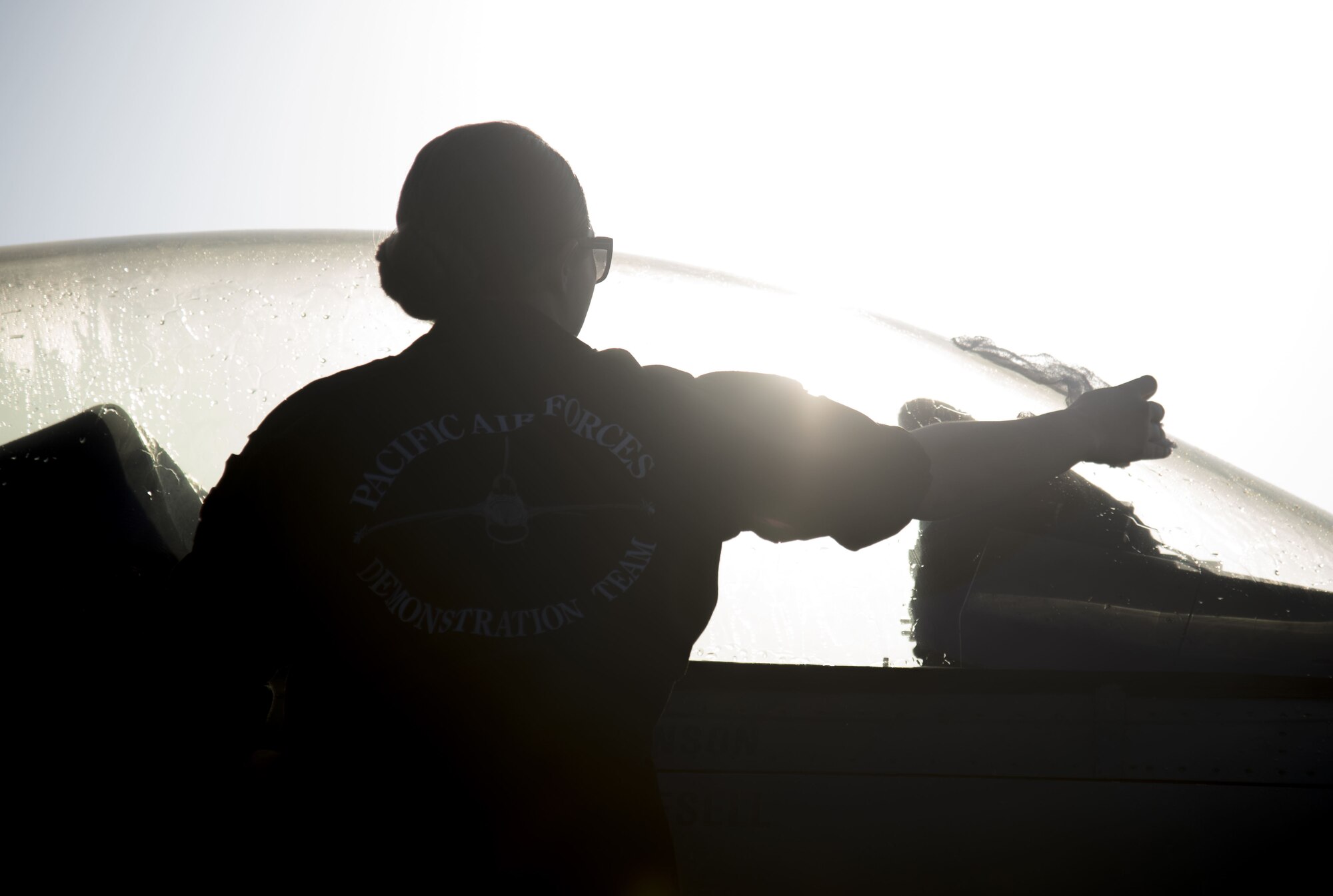 U.S. Air Force Senior Airman Emily Wall, a Pacific Air Forces' F-16 Demonstration Team crew chief, cleans off an F-16 Fighting Falcon's canopy before an airshow practice at Paya Lebar Air Base, Singapore, Feb. 3, 2018.