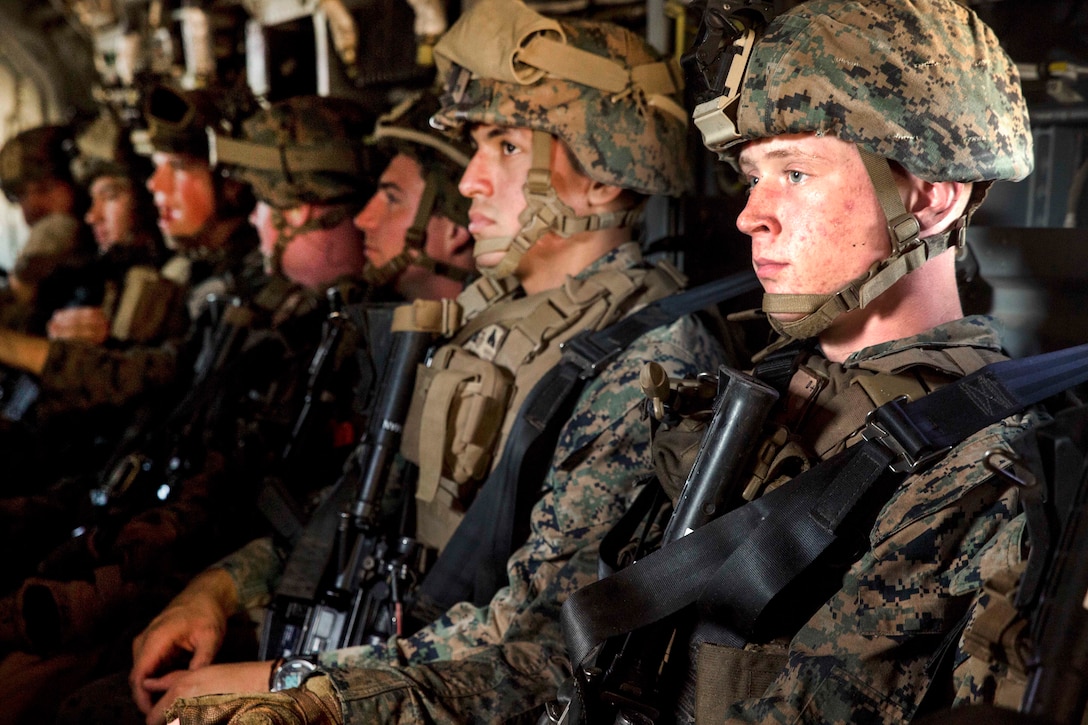 Marines and sailors are transported on an MV-22 Osprey aircraft.