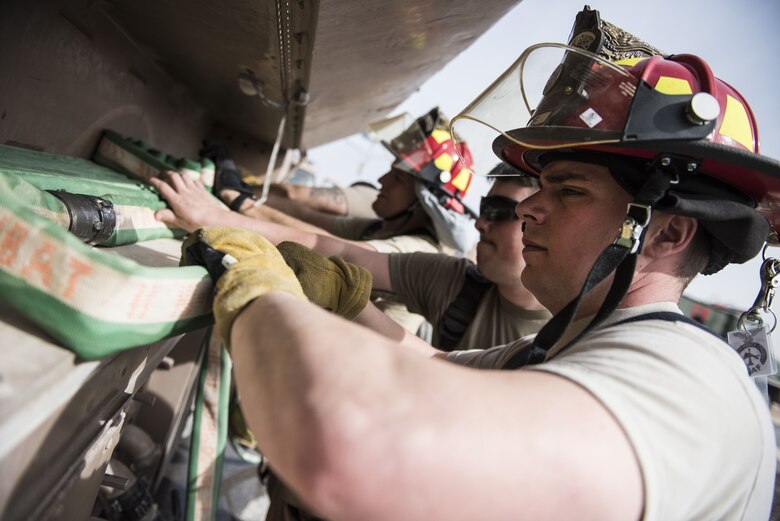 Firefighters assigned to the 332d Expeditionary Civil Engineer Squadron stow hoses after responding to a simulated structure fire during a coalition emergency response exercise February 9, 2017 at an undisclosed location in Southwest Asia. The exercise was designed to evaluate response times and build cohesion between coalition first responders. (Air Force photo by Staff Sgt. Joshua Kleinholz)
