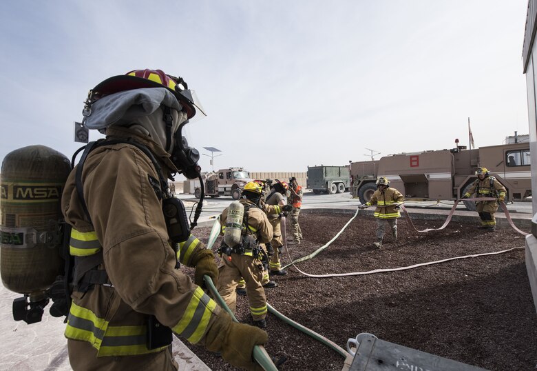Firefighters assigned to the 332d Expeditionary Civil Engineer Squadron respond to a simulated structure fire during a coalition emergency response exercise February 9, 2017 at an undisclosed location in Southwest Asia. After a simulated casualty was located and rescued by the U.S. Airmen, treatment was quickly administered by a German Air Force paramedic team. (Air Force photo by Staff Sgt. Joshua Kleinholz)
