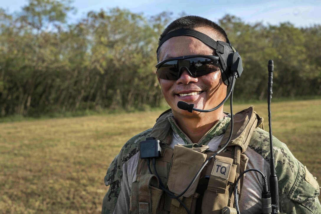 A sailor smiles as he prepares to participate in machine gun live-fire training.
