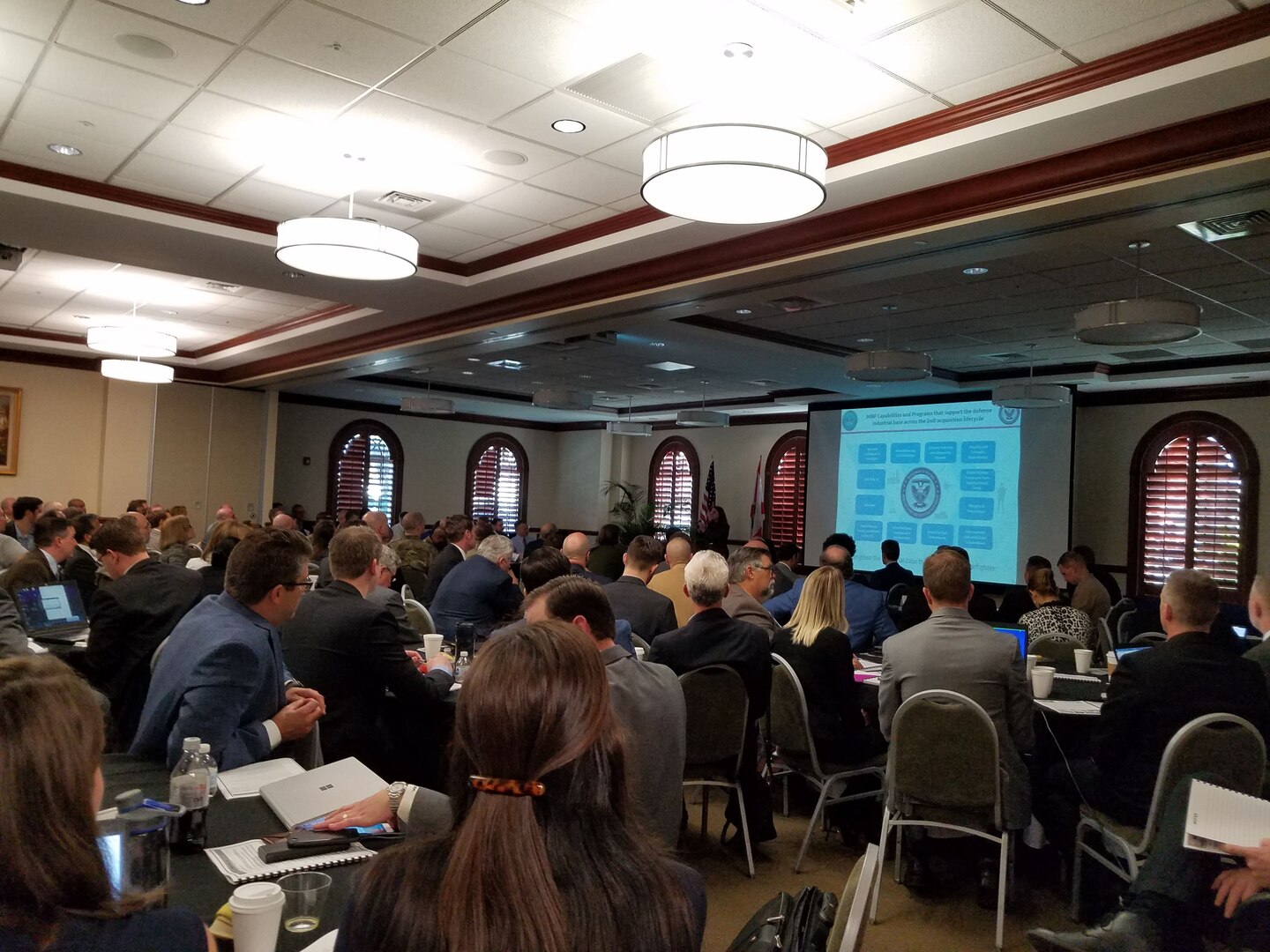 Audience members listen to a speaker present details on  additive manufacturing's benefits at the event in Tampa, Florida. Courtesy photo