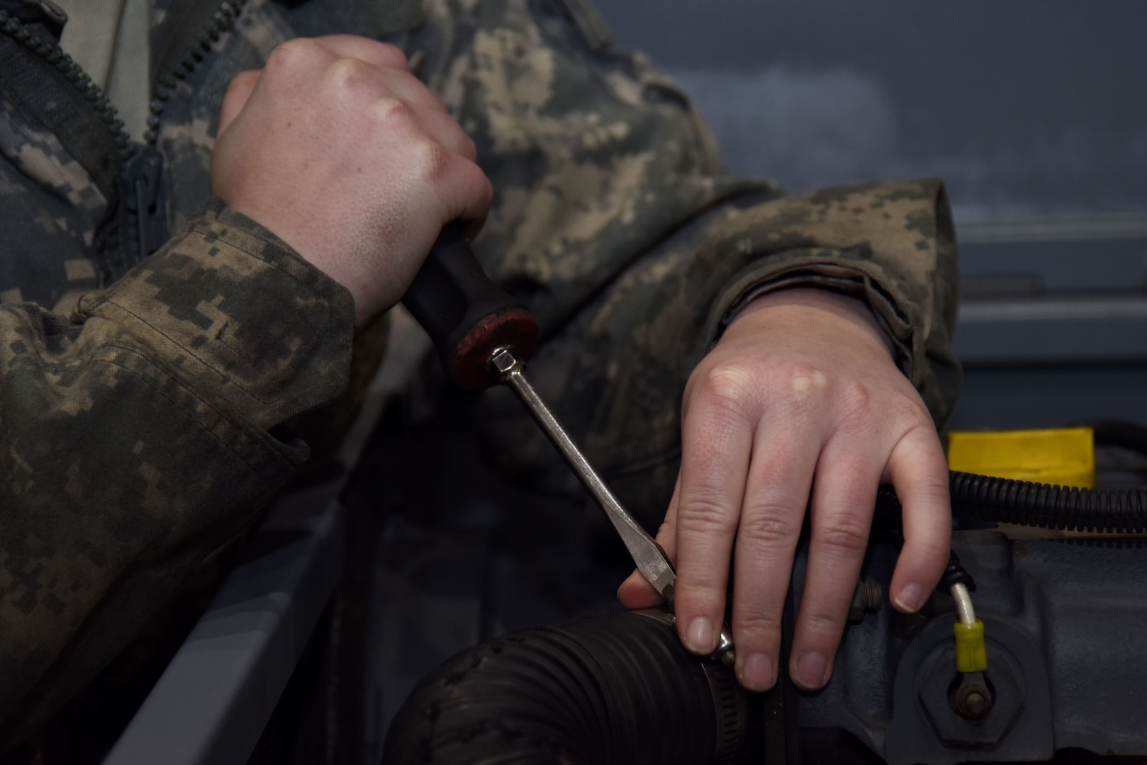 Airman 1st Class Hannah Christensen, 48th Equipment Maintenance Squadron aerospace ground equipment technician, tightens a hose clamp on a bomb lift at Royal Air Force Lakenheath, England, Feb. 7. AGE Airmen regularly inspect flightline equipment, performing two inspections per year on each item. (U.S. Air Force photo/Senior Airman Abby L. Finkel)