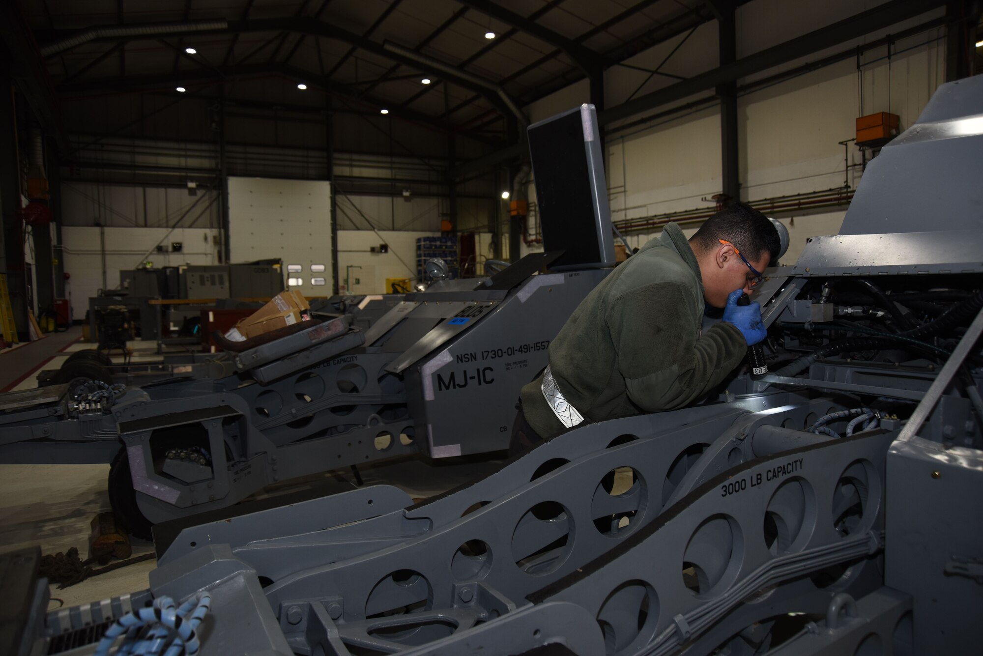 Airman 1st Class Andrei Perez, 48th Equipment Maintenance Squadron bomb lift maintainer, performs maintenance on a bomb lift at Royal Air Force Lakenheath, England, Feb. 7. AGE Airmen maintain flightline equipment such as generators, flood lights and bomb lifts. (U.S. Air Force photo/Senior Airman Abby L. Finkel)