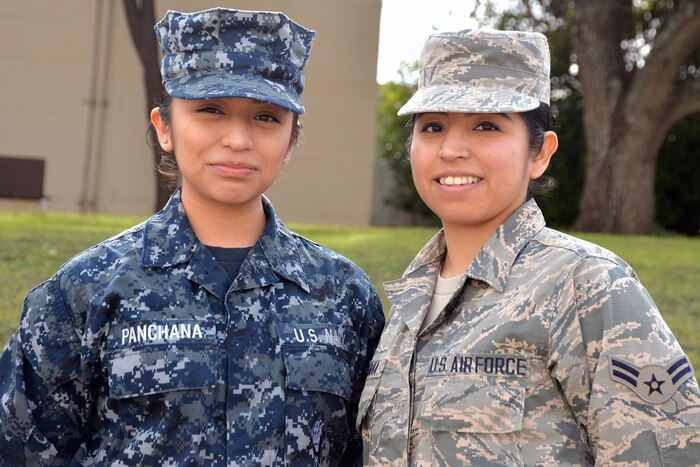 Two sisters pose for a picture - one with the Navy, the other with the Air Force.