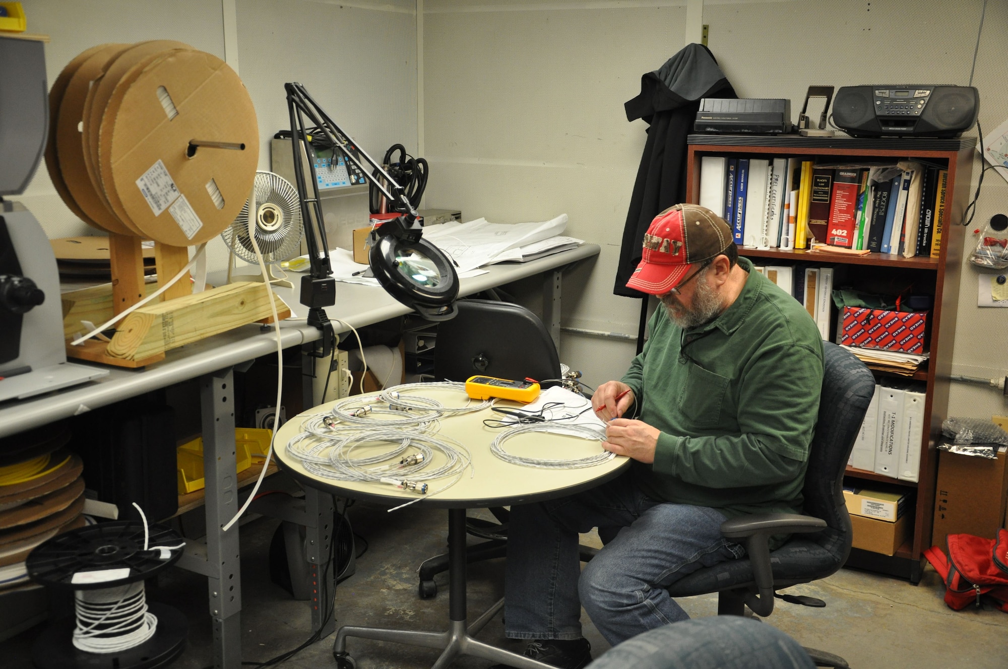 Dan Johnson, Quality Assurance Technician is checking continuity and isolation of the wires in the wiring harness. (U.S. Air Force photo/W. Eugene Barnett)