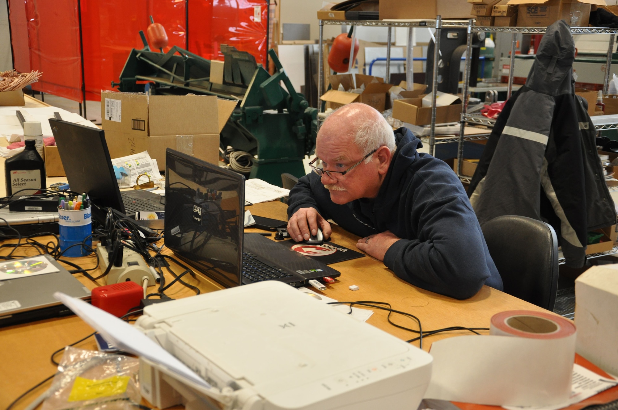 Jim Landers, Machinist is working on his laptop using programming computer aided manufacturing software to design critical parts for Air Force aircraft. (U.S. Air Force photo/W. Eugene Barnett)