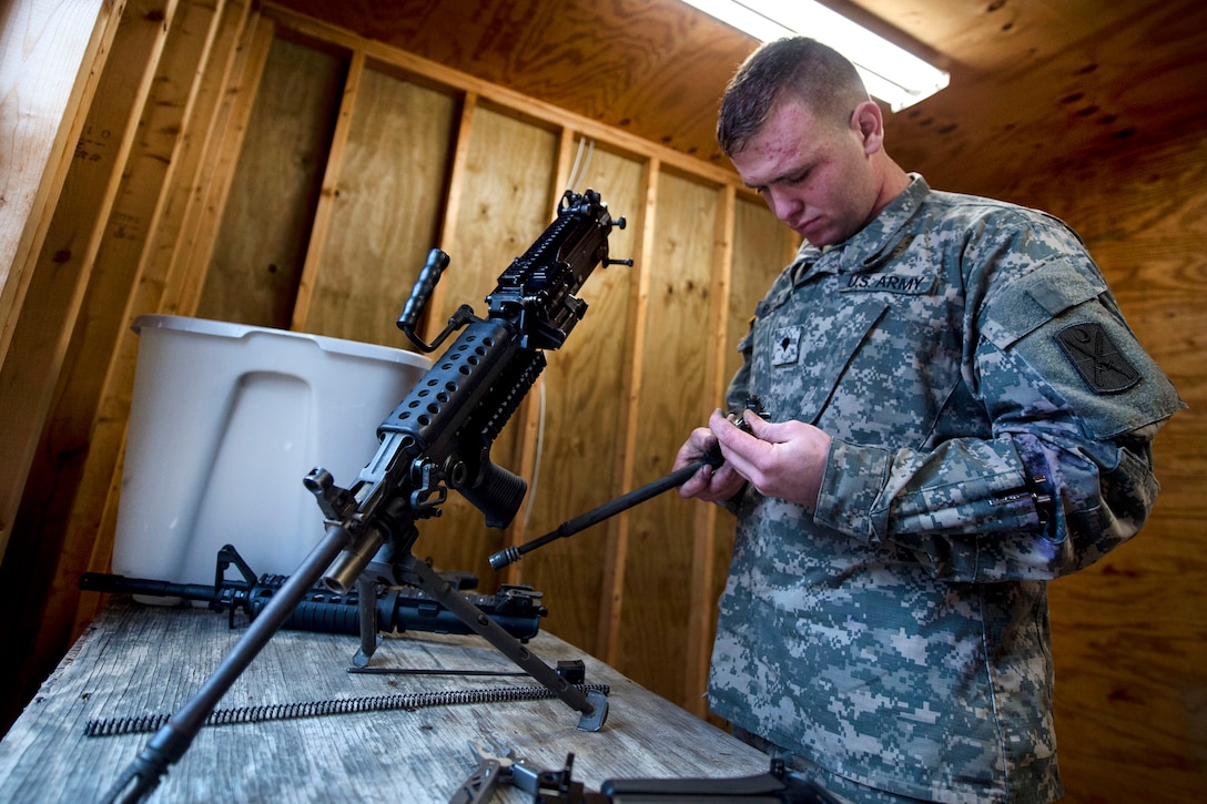 A soldier works to reassemble a weapon.