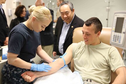 Dr. Kenneth Moritsugu (center), a member of the Uniformed Services University of the Health Sciences board of regents, watches students in the Medical Education and Training Campus medical laboratory technologist course practice blood draws at Joint Base San Antonio-Fort Sam Houston. The MLT course is one of several METC programs that offer enlisted students a degree pathway through USU’s College of Allied Health Sciences.