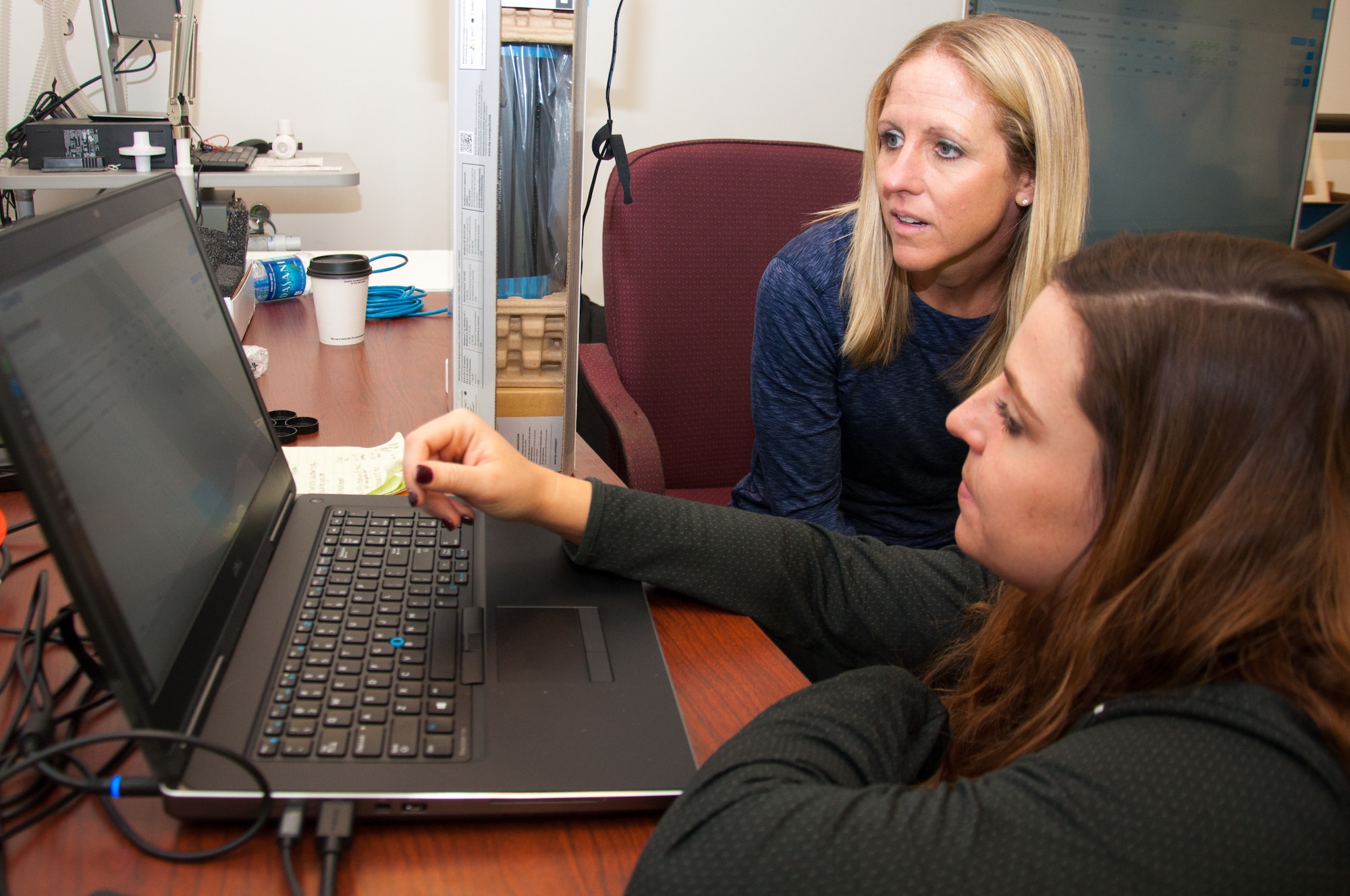Molly Wade (top), a research physiologist at the United States Air Force School of Aerospace Medicine, and Ashley Kesler, a USAFSAM contract research athletic trainer, go over some of the operations of the Dynamic Athletic Research Institute 3D biomakerless system before conducting a practice assessment. Wright-Patterson Air Force Base is the only base in the Department of Defense researching the many capabilities of the DARI system along with assessing Airmen who may be prone to musculoskeletal injury. (U.S. Air Force photo/John Harrington)