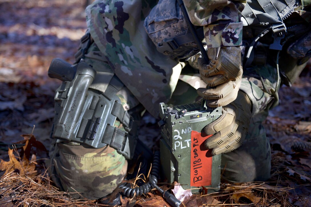 A soldier operates a radio.