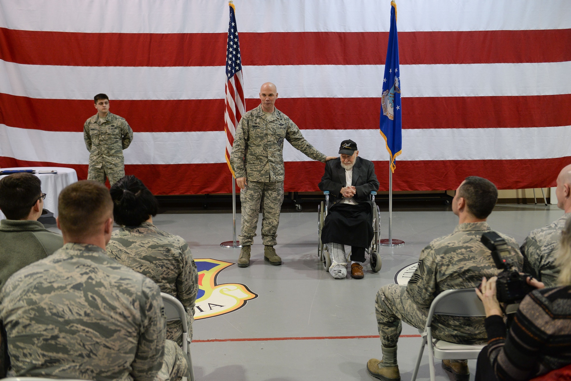 U.S. Air Force Col. Mike Manion, 55th Wing commander, introduces Gail Farrell, a 93-year old World War II and Korean War veteran who flew 21 missions as a tail gunner in the B-17 Flying Fortress, to more than 100 War Hawks assembled at the James M. McCoy Airman Leadership School Feb. 8, 2018. Manion, presented Farrell with an Air Medal with two oak leaf clusters; the European-African Middle Eastern Campaign Medal with three bronze service stars; the American Campaign Medal; the World War II Victory Medal; and the Honorable Service Lapel Button, WWII.