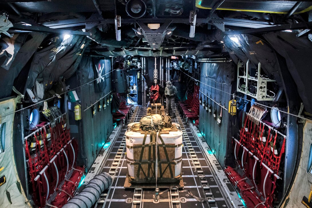 Airmen work on the brake systems of a Hercules aircraft while inside the aircraft.