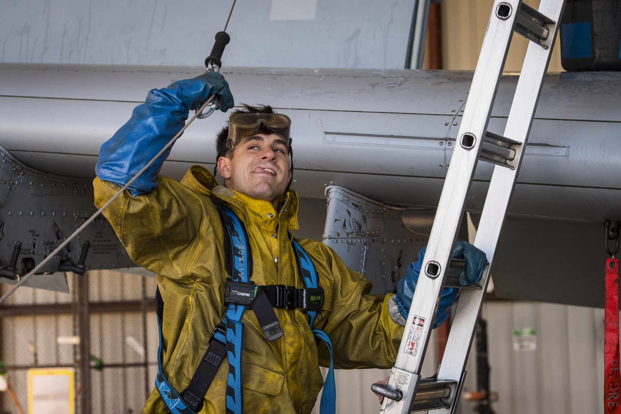 Airman 1st Class Jake Dromgold, 74th Aircraft Maintenance Unit crew chief, prepares to connect his harness to a hook, Feb. 8, 2018, at Moody Air Force Base, Ga. In addition to mechanical and electrical maintenance, A-10’s must be washed every 180 days or approximately 1,000 flying hours in order to control corrosion caused by residue from the gun and engine exhaust. (U.S. Air Force photo by Senior Airman Janiqua P. Robinson)