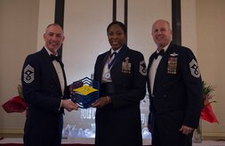 Chief Master Sgt. Larry C. Williams, U.S. Air Force Expeditionary Center command chief, left, recognizes Senior Master Sgt. Carol Dorman-Gore, 628th Force Support Squadron superintendent, center, along with Chief Master Sgt. Todd Cole, 628th Air Base Wing command chief, right, during the chief master sergeant recognition ceremony at the Charleston Club Feb. 10, 2018.