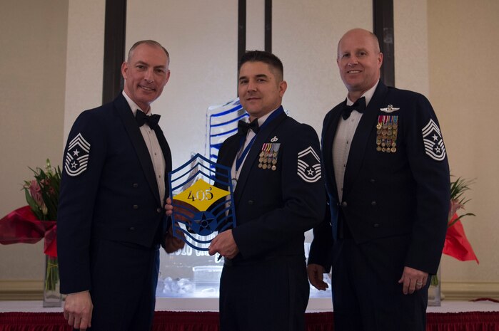 Chief Master Sgt. Larry C. Williams, U.S. Air Force Expeditionary Center command chief, left, recognizes Senior Master Sgt. Anthony Foster, 437th Operations Support Squadron superintendent, center, along with Chief Master Sgt. Todd Cole, 628th Air Base Wing command chief, right, during the Chief Master Sergeant Recognition Ceremony at the Charleston Club Feb. 10, 2018.