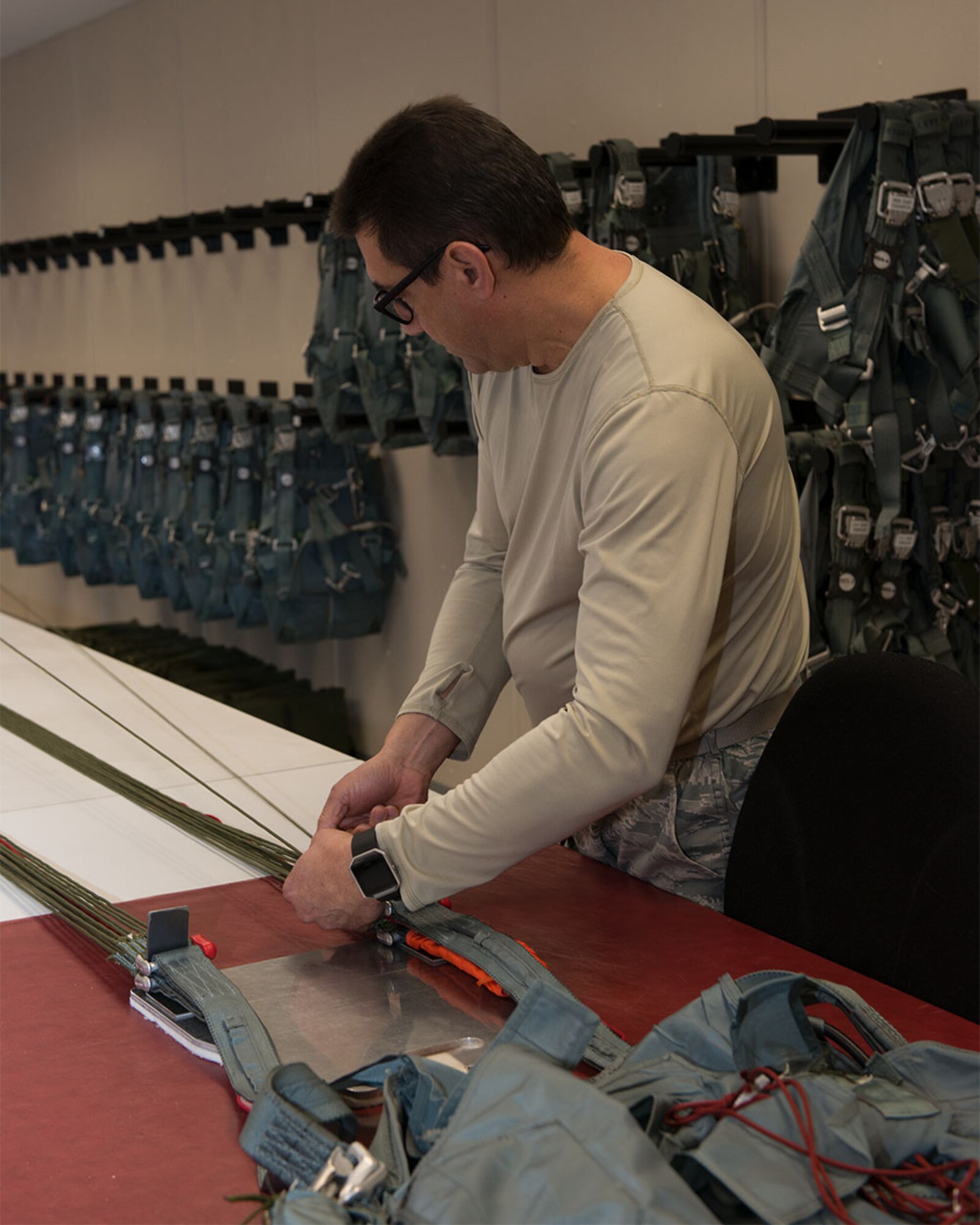 Master Sgt. Raymond Rosado counts parachute lines to ensure the lines are not tangled or frayed 1 Feb 2018 at Bradley Aire National Guard Base, East Granby, Conn. One of Rosado’s duties include inspecting survival equipment, like parachutes, for any deficiencies. (U.S. Air National Guard photo by 1st Lt. Jen Pierce/released)