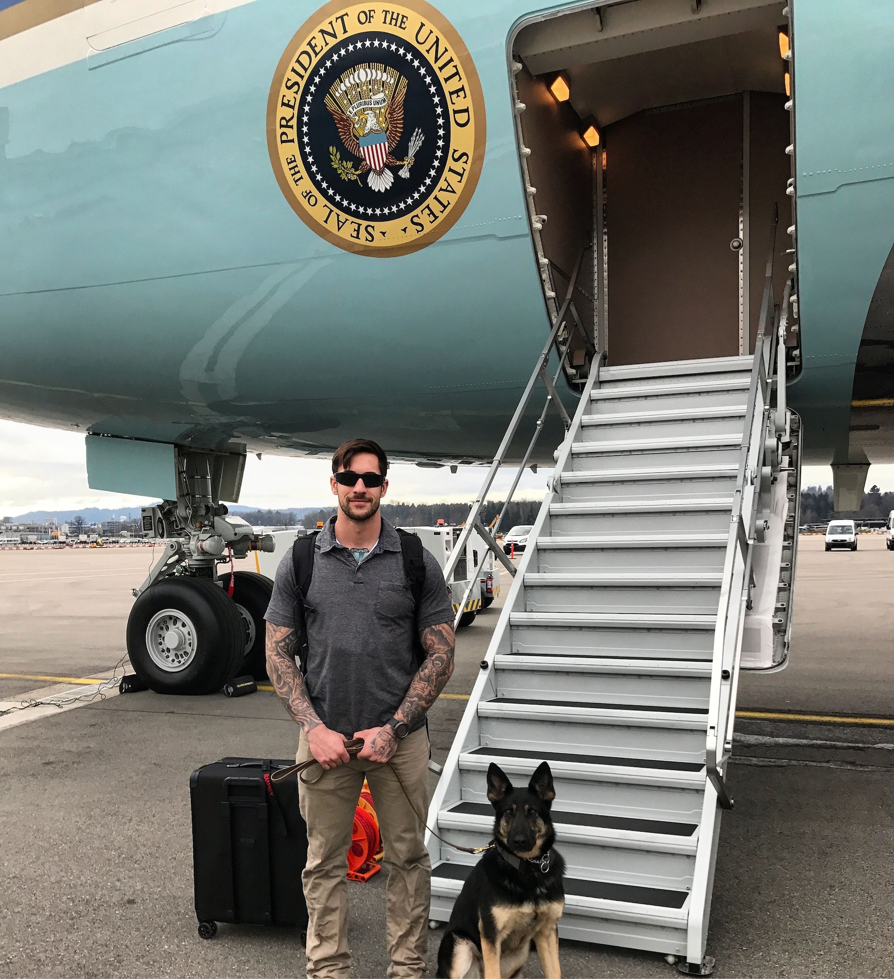 Air Force Staff Sgt. Michael Hensley, 52nd Security Forces Squadron military working dog handler, and Tina, 52nd SFS MWD, stand outside Air Force One Jan. 26, 2018. Two MWD teams were part of the security detail for President Donald J. Trump’s visit to Davos, Switzerland for the World Economic Forum, where they worked alongside Secret Service dog teams.