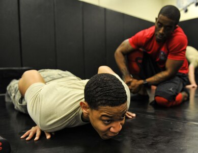 Staff Sgt. Chris Moore, right, 628th Security Forces Squadron Phoenix Raven, motivates Senior Airman Termarkius Bouknight, left, 628th SFS installation patrollman, during the push-up portion of a physical training exercise Jan. 31, 2018, at Joint Base Charleston, S.C.
