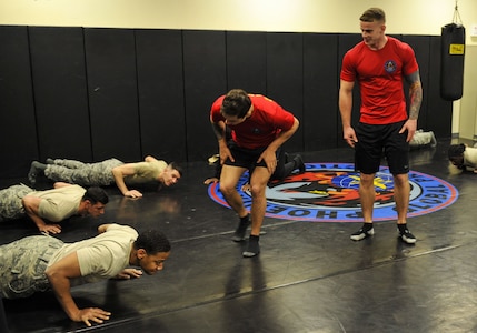 Staff Sgt. George Carty, center, 628th Security Forces Squadron Phoenix Raven and Senior Airman Cody Linday, right, 628th SFS Phoenix Raven, motivate candidates during the push-up portion of a physical training exercise Jan. 31, 2018, at Joint Base Charleston, S.C.