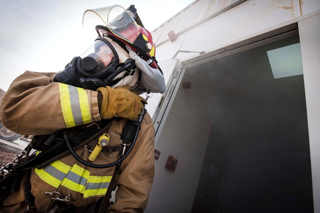 An Air Force firefighter responds to a simulated structure fire during a coalition emergency response exercise.