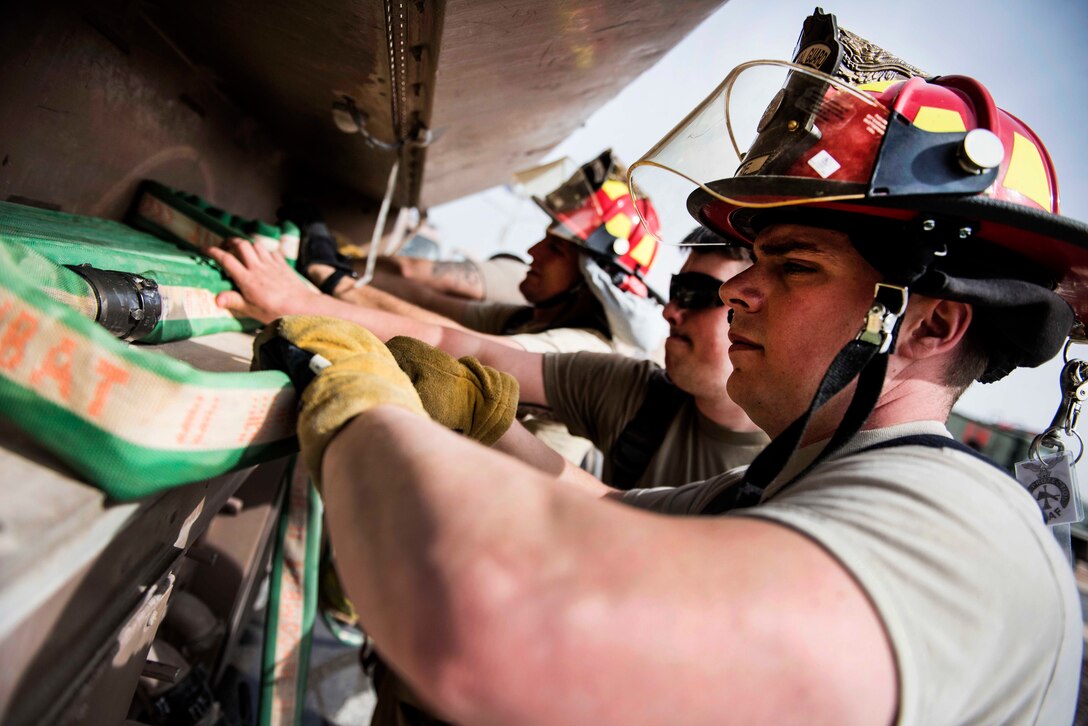 Air Force firefighters stow away their gear and hoses during a coalition emergency response exercise.