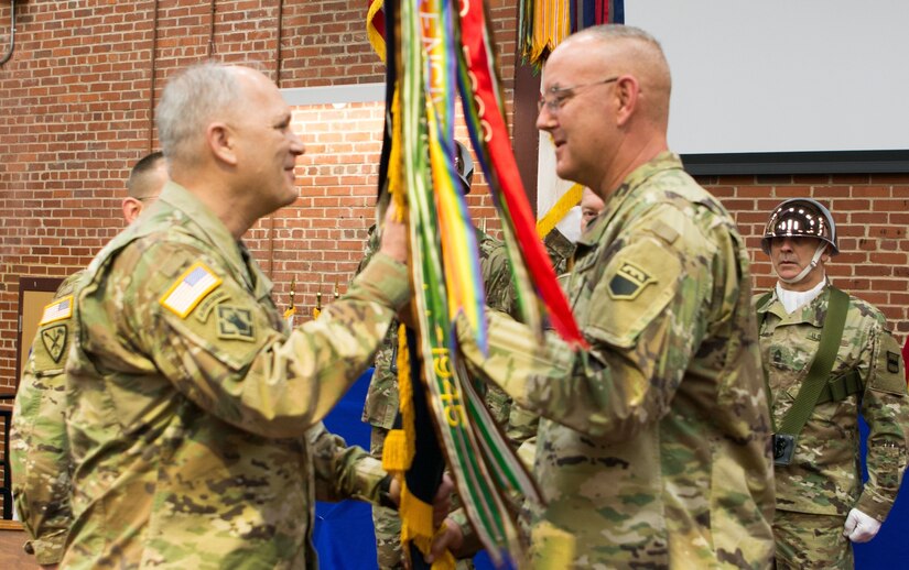 (Left) Maj. Gen. Bruce Hackett, commander of the 80th Training Command, receives the unit's guidon from Command Sgt. Maj. Jeffrey Darlington at the command's change of responsibility ceremony held at the Defense Supply Center Richmond, Virginia, during the 80th TC Commander's Readiness Workshop Feb. 8, 2018.  As the outgoing senior enlisted leader of the 80th TC, Darlington handed over the reins to the incoming senior enlisted leader Command Sgt. Maj. Dennis Thomas. (U.S. Army Reserve Photo by Maj. Addie Leonhardt)