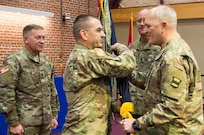 (Right) Maj. Gen. Bruce Hackett, commander of the 80th Training Command, passes the unit's guidon to Command Sgt. Maj. Dennis Thomas at the 80th's change of responsibility ceremony held at the Defense Supply Center Richmond, Virginia, during the 80th TC Commander's Readiness Workshop Feb. 8, 2018.  Sgt. Maj. Gerald Brandsasse (far left) looks on. (U.S. Army Reserve Photo by Maj. Addie Leonhardt)