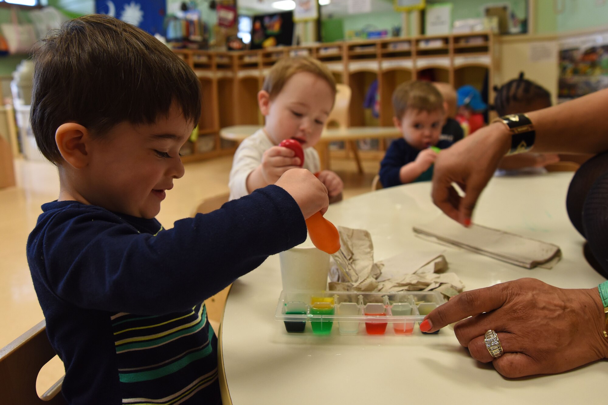 A Team Shaw child squeezes a dropper mixing food coloring and water during a lesson at the 20th Force Support Squadron Child Development Center at Shaw Air Force Base, S.C., Feb. 12, 2018.