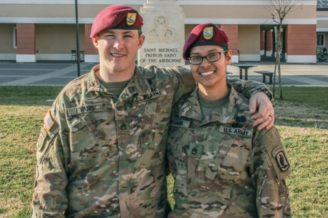 Two service members stand next to each other.