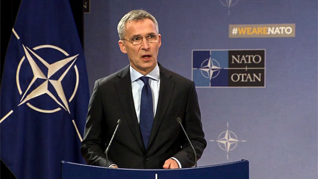 NATO's secretary general stands at a podium as he discusses alliance progress.