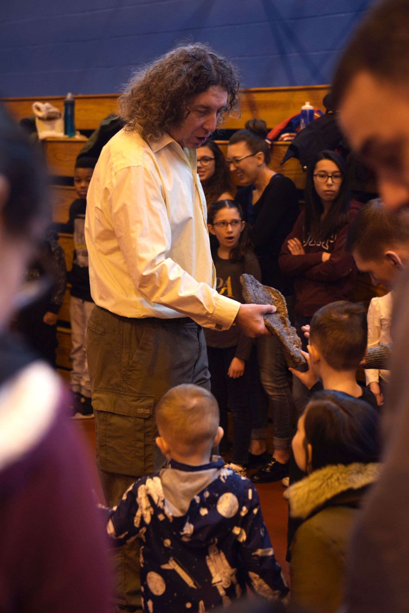 Eddy Collier, shows children a dinosaur fossil before starting the digital dome science show at RAF Mildenhall, England, Feb. 10, 2018. Families could also take Valentine’s Day themed family photos and enjoy various family activities together such as, storytime and arts and crafts before and after the shows. (U.S. Air Force photo by Airman 1st Class Alexandria Lee)