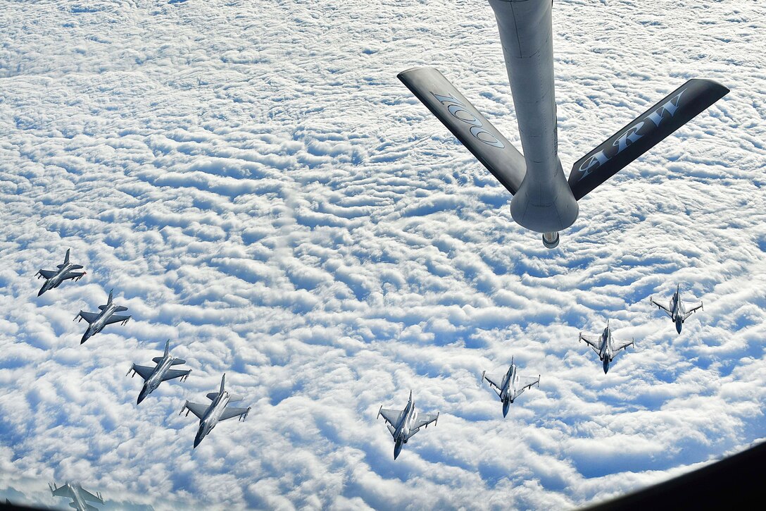 Four U.S. Air Force F-16C Fighting Falcons and four Swedish air force JAS 39 Gripens fly in formation.