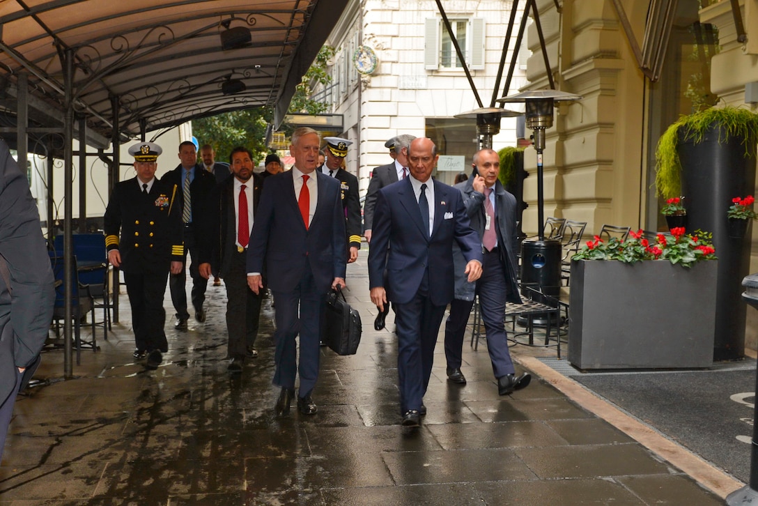 Defense Secretary James N. Mattis walks with the U.S. ambassador under an awning in Rome.
