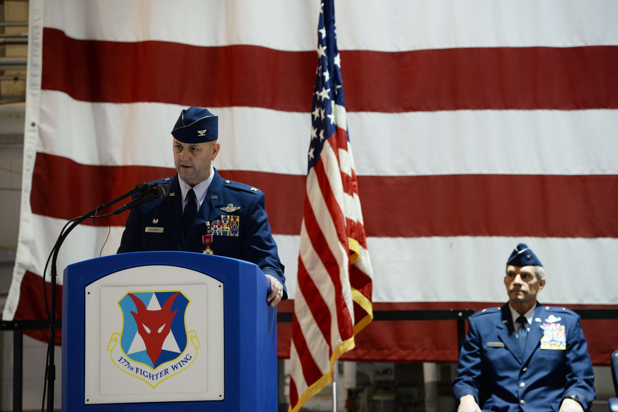 A picture of the Commander of the 177th Fighter Wing Col. John R. DiDonna delivering his farewell speech.