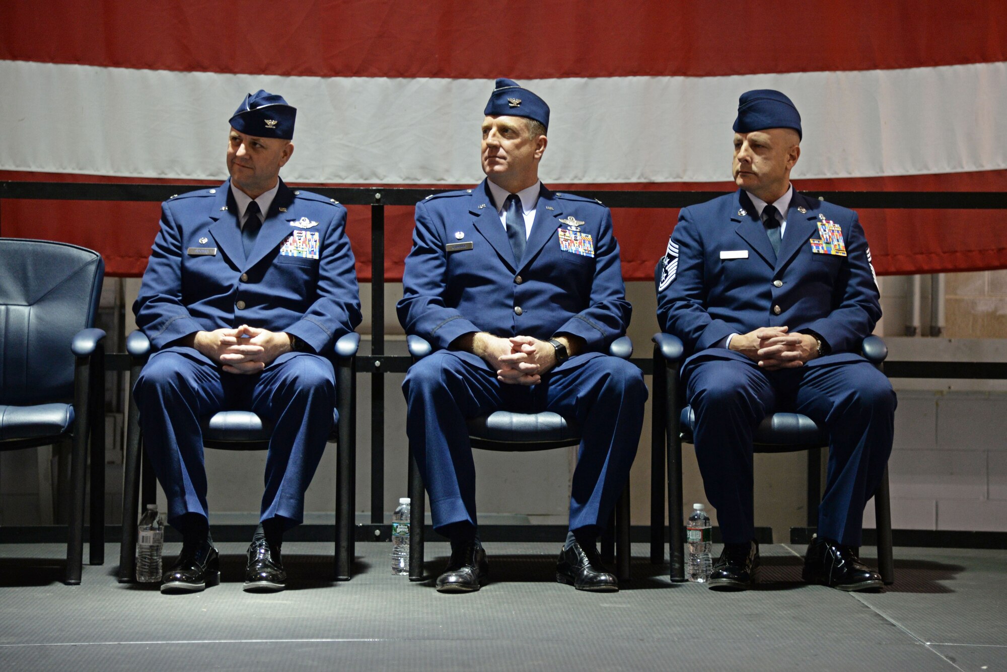 A picture of 177th Fighter Wing Commander John R. DiDonna, 177th Fighter Wing Operations Group Commander Bradford R. Everman, and 177th Fighter Wing Command Chief Master Sgt. James F. McCloskey sitting inside of the 177FW main hangar.