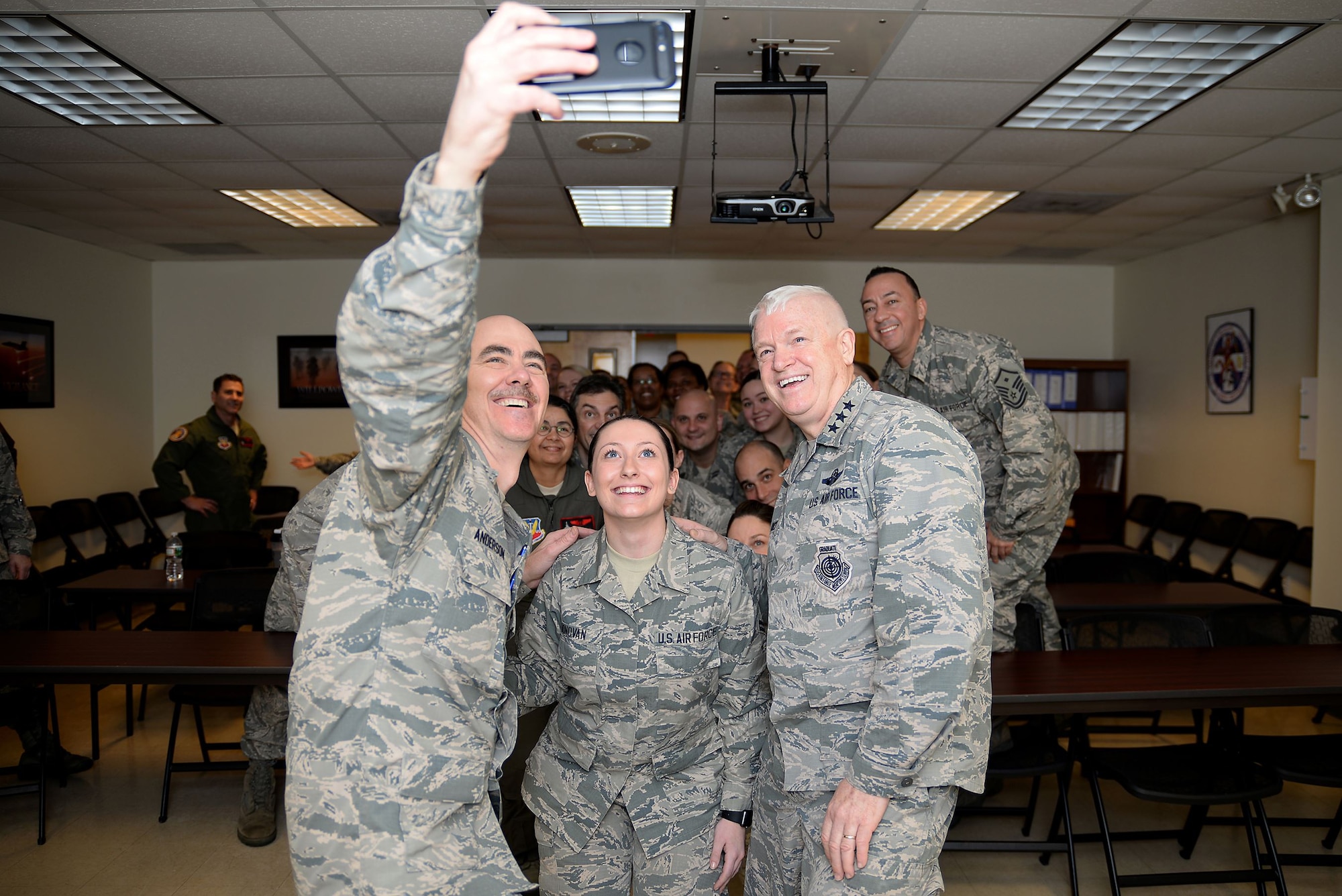 A picture of U.S. Air Force Lt. Gen. L. Scott Rice, director of the Air National Guard, and Command Chief Master Sgt. Ronald C. Anderson, command chief master sergeant of the ANG, taking a selfie with the Airmen of the Medical Group at the 177th Fighter Wing.