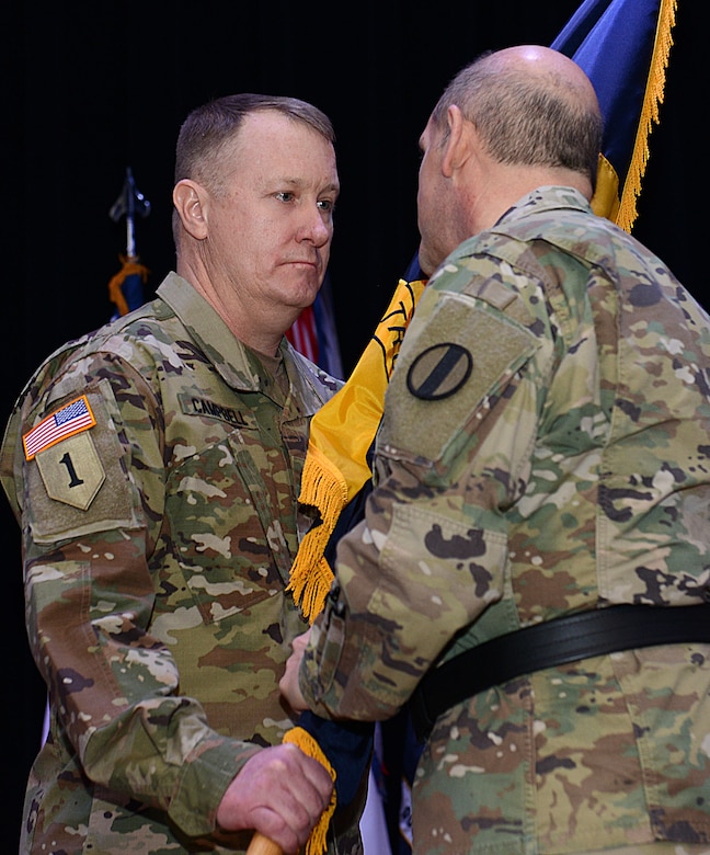 U.S. Army Lt. Col. Jayson Campbell, U.S. Army Training and Doctrine Command Special Troops Battalion incoming commander, left, accepts the unit colors from Maj. Gen. Paul Benenati, TRADOC deputy Chief of Staff, right, during a change of command ceremony at Joint Base Langley-Eustis, Va., Feb. 9, 2018.