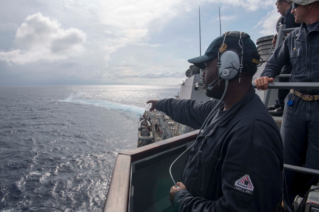 Navy Seaman Dorsey Cadette assigned to the guided-missile destroyer USS Stethem, points out a smoke signal during man-overboard training while conducting routine operations in the South China Sea.