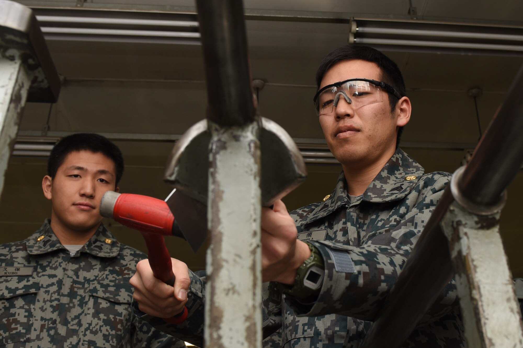 A Koku Jietai Cadet bends sheet metal as part of his visit to the 374th Maintenance Squadron fabrication flight during a Basic Maintenance Officer Tour at Yokota Air Base, Japan, Feb. 1, 2018.