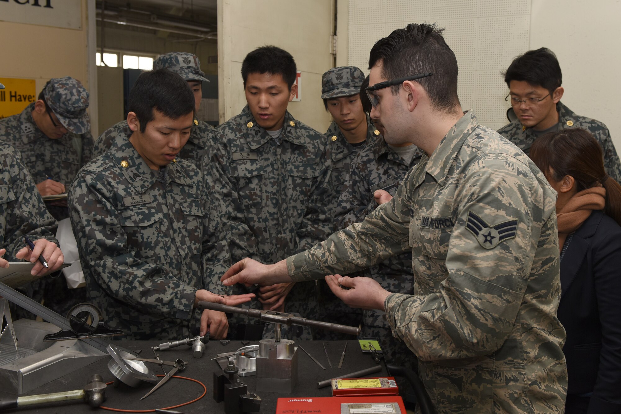 U.S. Air Force Senior Airman David Petrich, 374th Maintenance Squadron aircraft metals technology journeyman, showcases the tungsten carbide used in metals technology to Koku Jietai Cadets at a Basic Maintenance Officer Tour at Yokota Air Base, Japan, Feb. 1, 2018.