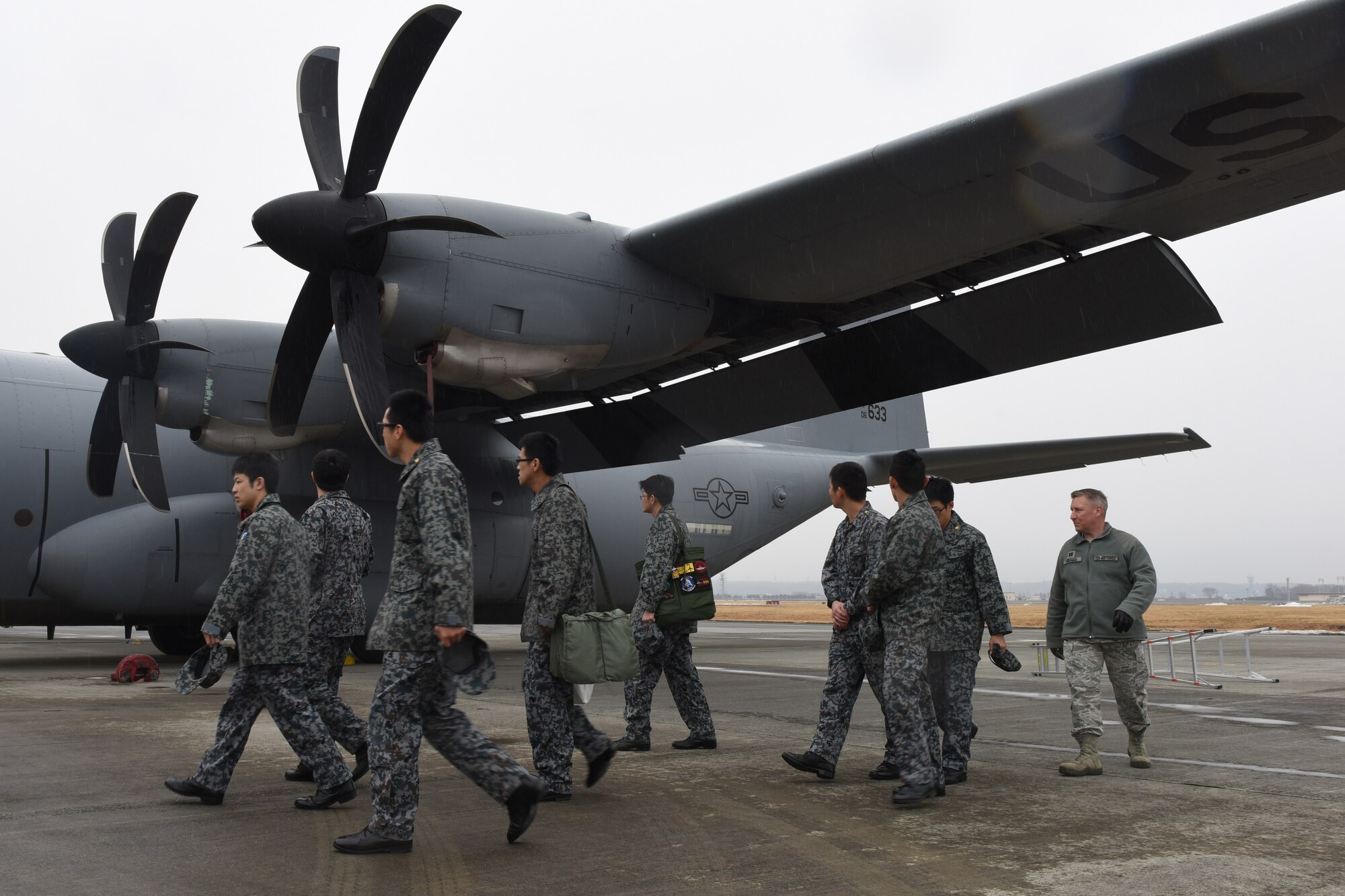 U.S. Air Force Capt. James Guthrie, maintenance exchange officer assigned to the Japanese Air Self-Defense Force’s First Technical School at Hamamatsu Air Base, escorts Koku Jietai Cadets around a C-130J Super Hercules during a Basic Maintenance Officer Tour at Yokota Air Base, Japan, Feb. 1, 2018.