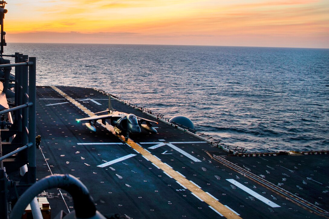 A Harrier II aircraft takes off from a flight deck.